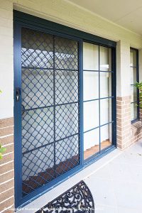A black sliding diamond grille security door.